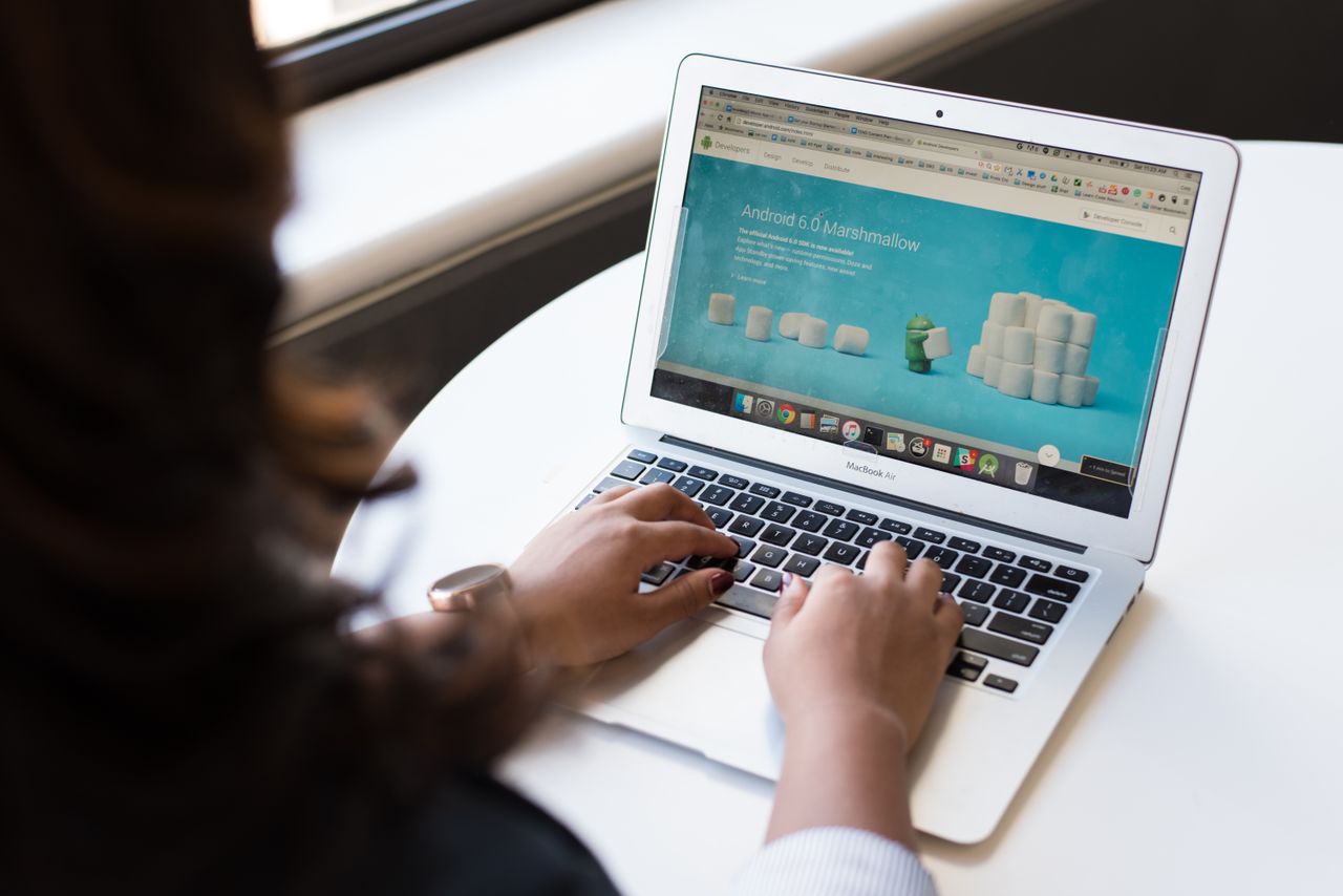 why-choose-us Businesswoman working on laptop with Android 6.0 Marshmallow webpage open.